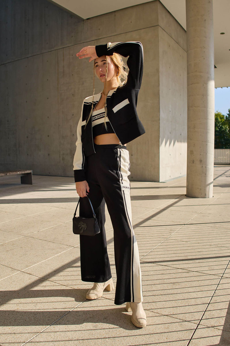 Ganzkörper Fashion Portrait schwarzer Trainingsanzug Crop Top moderne Betonarchitektur
