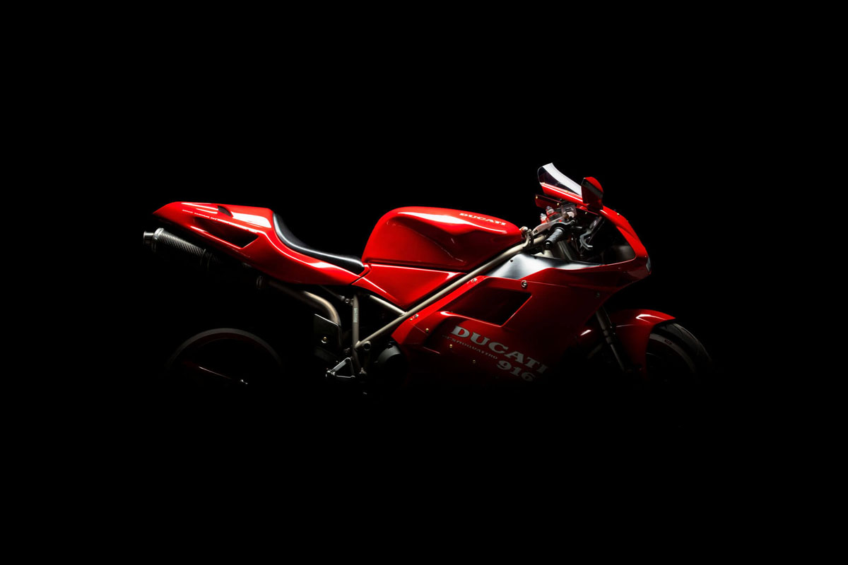 Motorradfotografie von roter Ducati 916 vor schwarzem Hintergrund