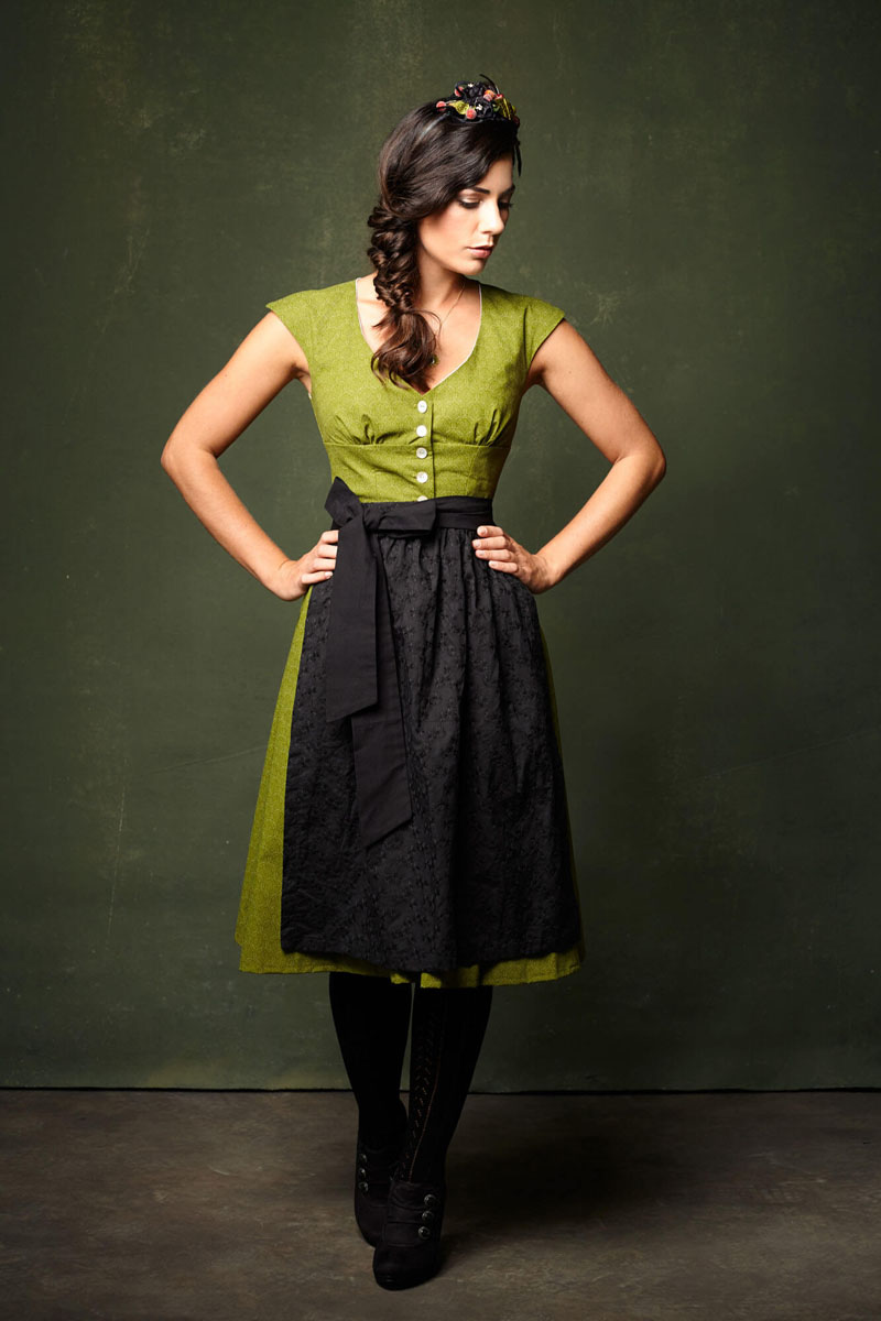 Frau in grünem Dirndl mit schwarzer Schürze und Blütenhaarschmuck - Ganzkörper Portrait Bayern